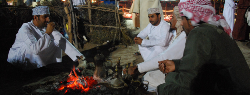 Drinking coffee by the fire in Oman